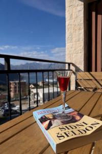 a glass of wine sitting on a book on a table at Azure Boka in Trojica