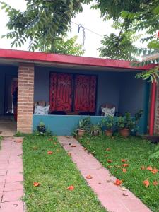 a blue house with a red door and a yard at Abril hospedaje in Juayúa