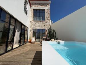 a house with a swimming pool next to a building at Casa Amanhada Apartamento Zero in Grândola