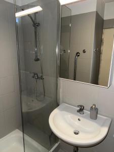a bathroom with a sink and a shower with a mirror at Cloud 12 - Penthouse in der Innenstadt mit Blick über die gesamte Skyline von Bremerhaven in Bremerhaven