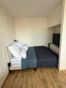 a bedroom with a bed with pillows and a television at Cloud 12 - Penthouse in der Innenstadt mit Blick über die gesamte Skyline von Bremerhaven in Bremerhaven