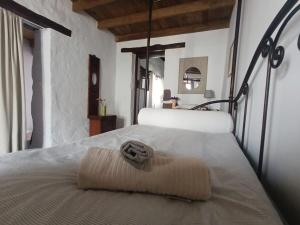 a bed with a towel on it in a room at Casa MaLuMi - Historisches Stadthaus in Haría in Haría