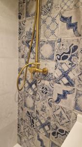 a bathroom with a wall with blue and white tiles at La Posada del Olivar in Baena
