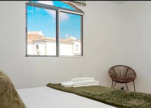 a bedroom with a bed and a chair and a window at Flamingo 1 in Arguineguín