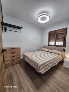 a bedroom with a bed and a dresser in it at Brisa Marina in Cullera