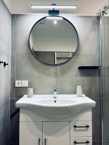 a bathroom with a white sink and a mirror at Schwanstein Apartments Füssen ZENTRUM in Füssen +15 photos