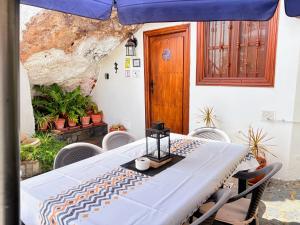 a table with a blue umbrella on a patio at Finca Las Polinarias Casa Cueva en Fasnia in Santa Cruz de Tenerife