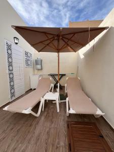 a patio with a table and chairs and an umbrella at Dar anas in Fafou