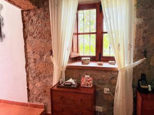 a window in a room with a wooden dresser and a dresser with at Finca Las Polinarias Casa Cueva en Fasnia in Santa Cruz de Tenerife