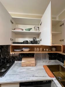 a kitchen with white cabinets and a counter top at Dar anas in Fafou