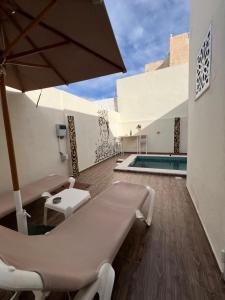 a patio with a table and an umbrella and a pool at Dar anas in Fafou