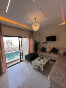 a living room with a couch and a chandelier at Dar anas in Fafou