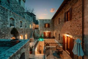 a courtyard in a stone building with a table and chairs at Μikri Arktos Boutique Hotel in Dimitsana
