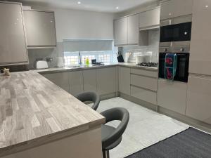 a kitchen with a large wooden table and chairs at Luxury 4BR Bungalow in Hackbridge