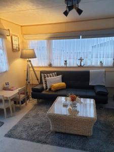 a living room with a black couch and a table at Holiday Sea Caravan in Withernsea