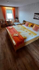 a large bed in a bedroom with a wooden floor at Ferienwohnung Heidebergblick in Lawalde +11 photos
