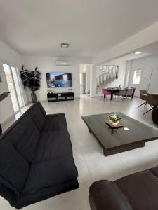 a living room with a couch and a table at Villa Artemis - 150m from Kapparis Beach in Paralimni