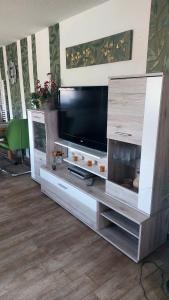 a large entertainment center with a flat screen tv at Ferienwohnung Heidebergblick in Lawalde