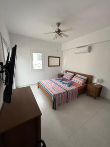 a bedroom with a bed and a ceiling fan at Villa Artemis - 150m from Kapparis Beach in Paralimni +21 photos