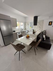 a kitchen and living room with a white table and chairs at Villa Artemis - 150m from Kapparis Beach in Paralimni