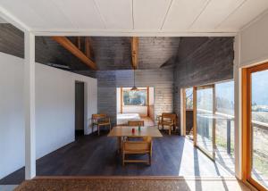 an open living room with a table and a bed at OKANiWA 丘庭 in Nagiso