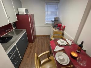 a small kitchen with a table and a refrigerator at Shiraz Suite in Calgary