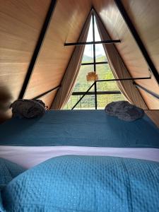 a bed in a tent with a large window at Chalé 4 Elementos Teresópolis - vista panorâmica e privacidade in Teresópolis