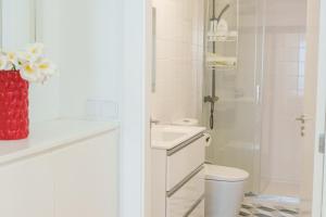 a bathroom with a toilet and a sink and a shower at Dolce Vita Heroismo in Porto +28 photos