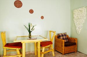 a table with two chairs and a vase with flowers at Spa Elpis in Kigali