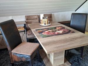 a wooden table with two chairs and a painting on it at ruhiger als im Hotel keine andere Gäste 3 Betten 2 Schlafzimmer in Merkendorf