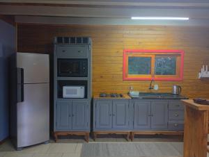 a kitchen with blue cabinets and a white refrigerator at Cabana mandaçaia in Timbe do Sul