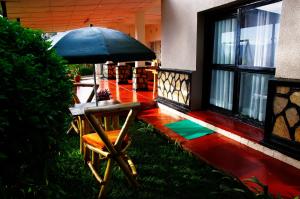 a chair with an umbrella in front of a house at Spa Elpis in Kigali +44 photos