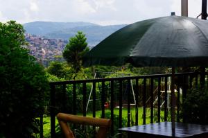 a table with an umbrella on a balcony with a view at Spa Elpis in Kigali