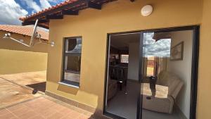 a house with a sliding glass door to a patio at The Pebbles-UA in Mahikeng