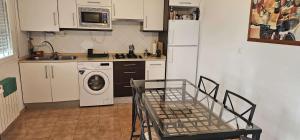a kitchen with a white refrigerator and a washing machine at HAIZEA Aire Apartamento 4 in Sopuerta