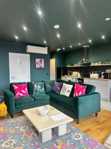 a living room with a green couch and a table at STUNNING Apartments in Jarrow, next to A19 & Tyne Tunnel in East Howdon