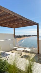 a patio with chairs and a view of a beach at Apartamentos Rossio Mar in Albufeira