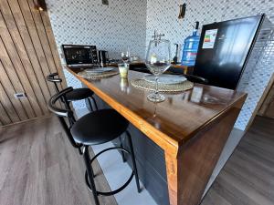 a bar with wine glasses on top of it at Rukamar Cocholgue in Tomé