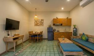 a living room with a couch and a table and a kitchen at Sari Dana Villas in Sanur