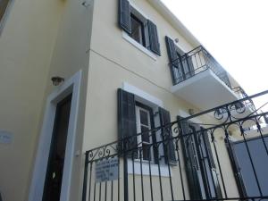 a white building with black windows and a fence at Costa's House in Kiónion +2 photos