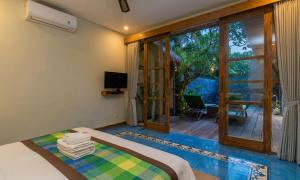 a bedroom with a bed and a sliding glass door at Sari Dana Villas in Sanur