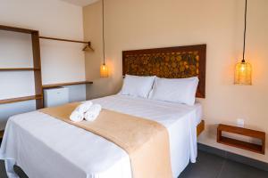 a bedroom with a bed with two towels on it at Pousada Brisa do Cardeiro in São Miguel do Gostoso