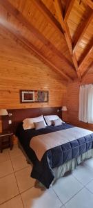 a bedroom with a large bed in a wooden room at Encanto del Rio in Villa La Angostura +148 photos