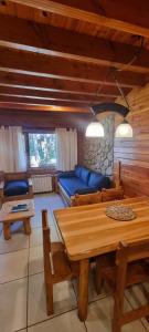 a living room with a blue couch and a table at Encanto del Rio in Villa La Angostura