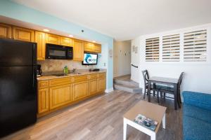 a kitchen with a black refrigerator and a table at Amazing Oceanfront Accessible Beach Amazing View in Myrtle Beach +60 photos