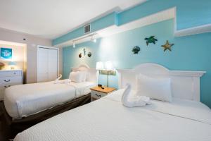 a bedroom with two beds and a blue wall at Amazing Oceanfront Accessible Beach Amazing View in Myrtle Beach
