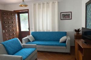 a living room with a blue couch and a tv at Villa Mesiano in Polistena
