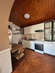 a kitchen with white cabinets and a wooden ceiling at Villa Mesiano in Polistena