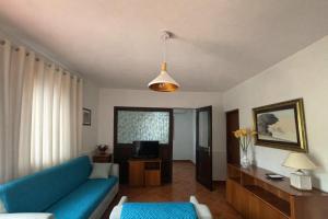 a living room with a blue couch and a television at Villa Mesiano in Polistena +3 photos