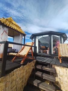 a deck with two chairs and a gazebo at Q'OTA TAYPY LODGE in Puno